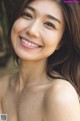 A woman with long brown hair smiling at the camera.