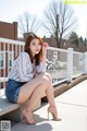 A woman sitting on a bench with her legs crossed.