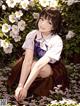 A girl sitting in a field of white flowers.