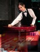 A woman in a tuxedo playing roulette at a casino table.