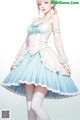 A woman in a blue and white dress is posing for a picture.