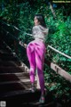 A woman in pink leggings standing on a set of stairs.