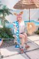 A woman sitting on a chair next to a swimming pool.