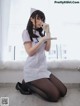 A woman dressed as a nurse sitting on the floor.